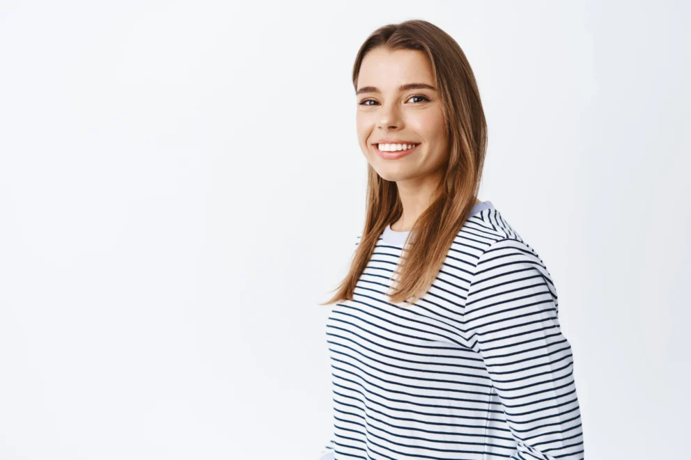 portrait-young-caucasian-woman-with-fair-hair-white-smile-turn-head-front-looking-friendly-natural-front-standing-white-wall (1)