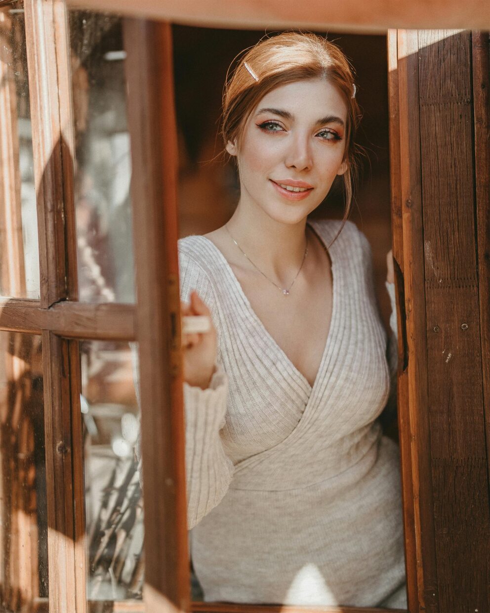 woman smiling while looking outside of a window after getting periodontics with our Bethesda dental specialists